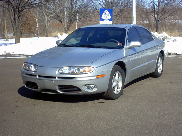 Silver Oldsmobile Aurora sedan, front 3/4 view in snowy parking lot