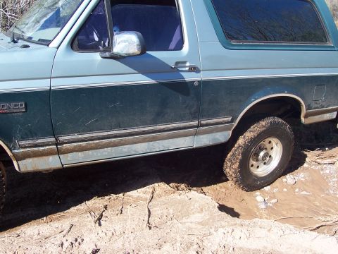 1996 Ford Bronco - This Ford Bronco is navigating a muddy off-road trail.
