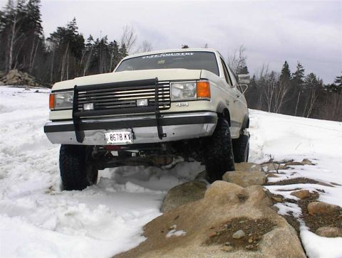 1988 Ford Bronco - 1988 Ford Bronco navigating a snowy, rocky trail.