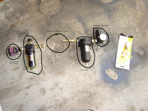 1991 Ford Bronco - Various components of an air compressor system are arranged on a concrete surface.