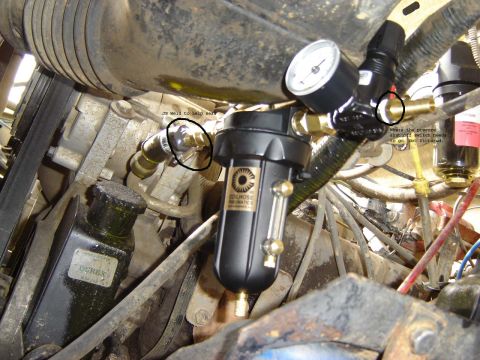 1991 Ford Bronco - Close-up view of an engine bay showing an air compressor system with a pressure gauge and labeled components.