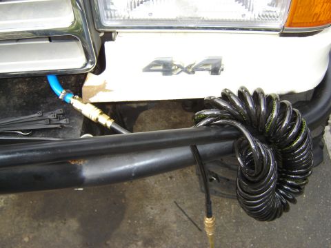 1991 Ford Bronco - Front view of a white 1991 Ford Bronco 4x4 showing an air hose attached to the bumper.