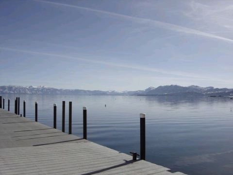 1995 Ford Bronco - A wide view of a lake with a wooden dock in the foreground and mountains on the horizon.
