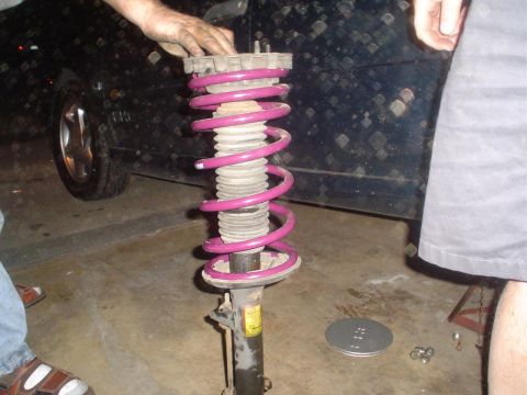 1993 Ford Taurus - Front strut assembly with a pink coilover spring, likely for a car suspension upgrade.