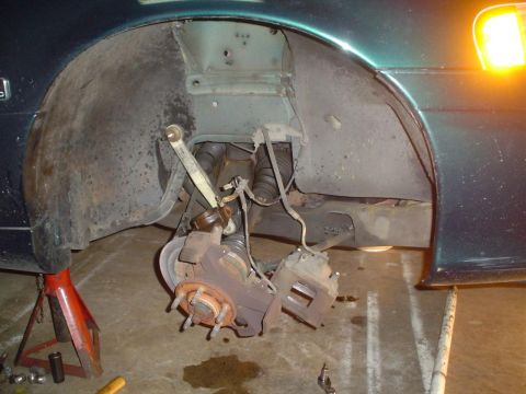 1993 Ford Taurus - The front suspension and brake components of a vehicle are exposed and undergoing maintenance.