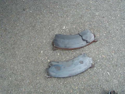 1993 Ford Probe - Damaged brake rotors lie on a textured asphalt surface, indicating a need for replacement.