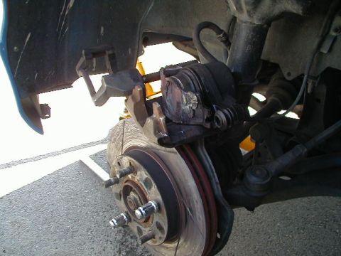1993 Ford Probe - Front brake caliper and rotor assembly on a vehicle.