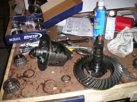 1996 Ford Bronco - Differential parts and tools laid out on a wooden surface.
