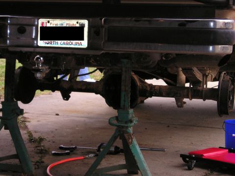 1996 Ford Bronco - Vehicle's rear axle and suspension are elevated on jack stands, with a North Carolina license plate in view.