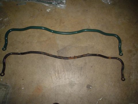 1993 Ford Taurus - Comparison of a new green sway bar next to an old, rusted sway bar.