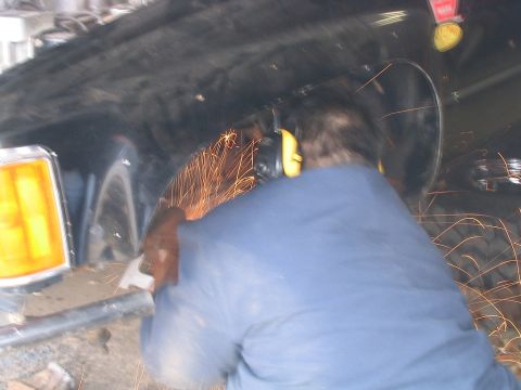 1986 Ford F-150 - Grinding sparks fly as metal work is done on a vehicle's fender.