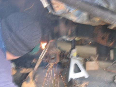 1986 Ford F-150 - Welding repairs are underway on the vehicle's undercarriage.