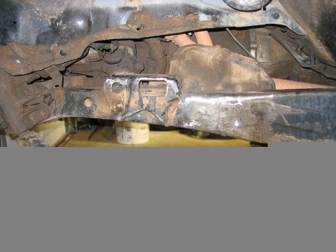 1986 Ford F-150 - The heavily rusted frame of a vehicle is shown, with some areas appearing to have been welded.