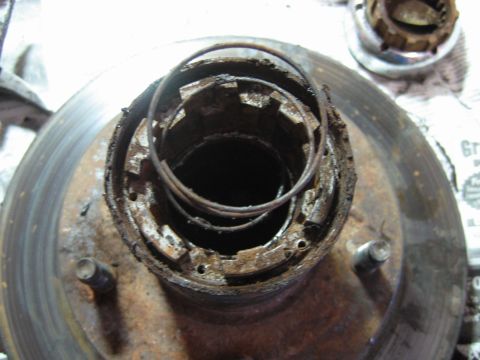 1992 Ford Bronco - Close-up of a heavily corroded wheel hub assembly, showing internal components and a brake rotor.