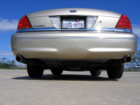 2000 Ford Crown Victoria - Gold 2000 Ford Crown Victoria rear view showing dual exhaust pipes and Texas plate.