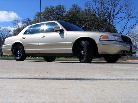 2000 Ford Crown Victoria - Tan 2000 Ford Crown Victoria with black steel wheels parked outdoors.