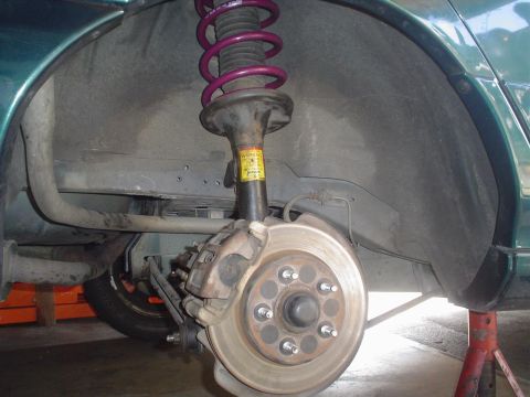 1993 Ford Taurus - Close-up view of a vehicle's rear suspension and braking system, with a bright purple coilover shock.