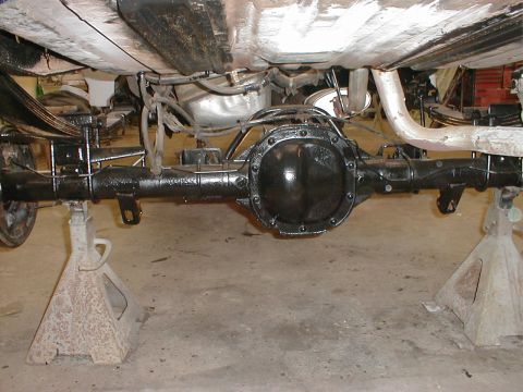 1991 Ford F-150 - Underside view of a vehicle's rear axle assembly, supported by jack stands in a garage.