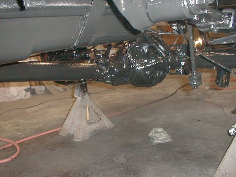 1991 Ford F-150 - The rear axle and suspension of a vehicle are supported by jack stands and appear to have been recently painted.