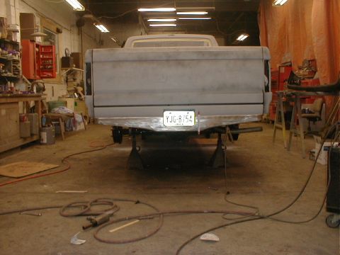 1991 Ford F-150 - Rear view of a gray 1987 Ford F-150 truck undergoing repairs in a workshop.