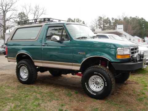1995 Ford Bronco - This 1995 Ford Bronco is shown in a three-quarter front view, a green exterior, a roof rack, and an aftermarket front bumper.