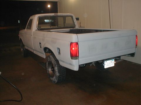 1991 Ford F-150 - Rear view of a 1991 Ford F-150 pickup truck in primer, parked inside a garage.
