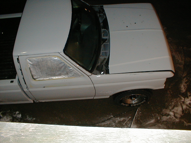White 1991 Ford F-150 pickup truck with driver's side door open and window taped off
