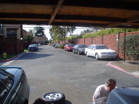 1993 Ford Taurus - A white sedan is parked on the right side of the street, viewed from a covered area.