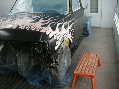 1991 Ford F-150 - A 1991 Ford F-150 truck is prepared for custom paintwork, showing flame graphics on the hood and fender.