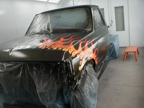 1991 Ford F-150 - A truck with a custom flame paint job is being worked on in a spray booth.
