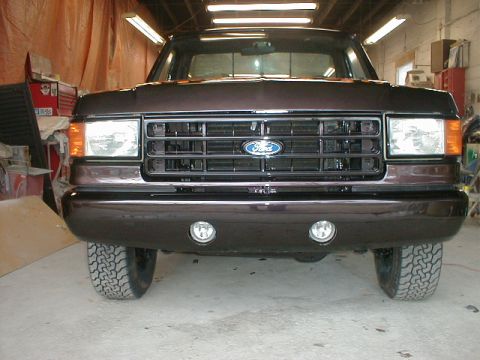 1991 Ford F-150 - This 1991 Ford F-150 features a dark brown paint job, a prominent Ford grille, and front fog lights.