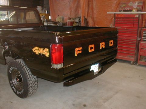 1991 Ford F-150 - This 1991 Ford F-150 pickup features gold 4x4 and FORD badging on its dark brown exterior.