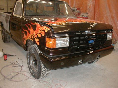 1991 Ford F-150 - This Ford F-150 shows custom flame paintwork and appears to be in a workshop setting.