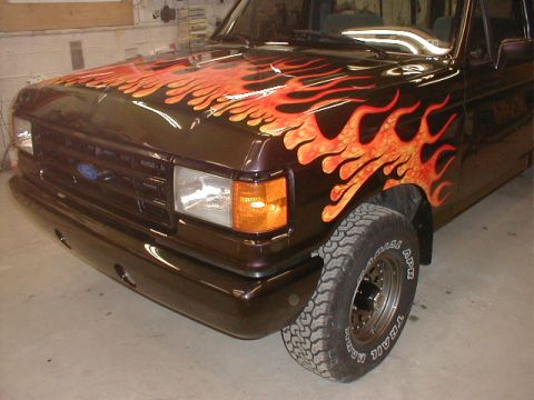 1991 Ford F-150 - This 1991 Ford F-150 features a striking custom flame paint job on its hood and front fender.