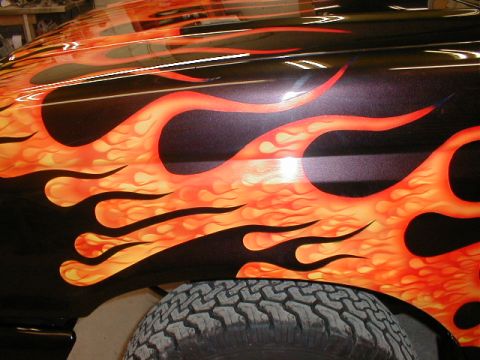 1991 Ford F-150 - Truck fender with custom flame paint job and a tire visible below.