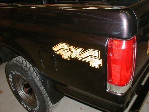 1991 Ford F-150 - Rear view of a black pickup truck a 4x4 decal with a flame design.