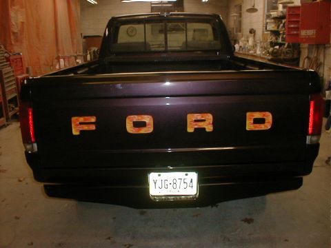 1991 Ford F-150 - Rear view of a 1991 Ford F-150 pickup truck with custom flame decals on the tailgate.