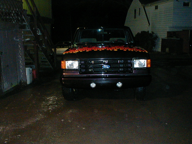Black 1991 Ford F-150 front view with orange flames on hood