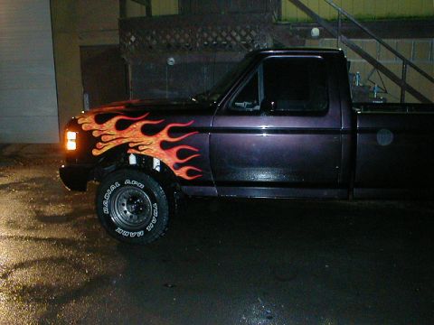 1991 Ford F-150 - Side view of a 1991 Ford F-150 pickup truck custom flame graphics on the front fender and hood.