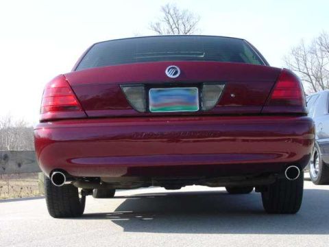 1998 Ford Crown Victoria - Rear view of a dark maroon Mercury full-size sedan showing the Mercury emblem on the trunk, blacked-out taillight panel, and dual chrome ex…