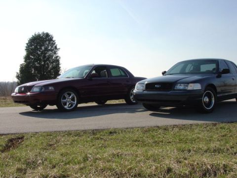 1998 Ford Crown Victoria - Two full-size sedans, a maroon Mercury Marauder and a black Ford Crown Victoria, parked side by side on pavement.