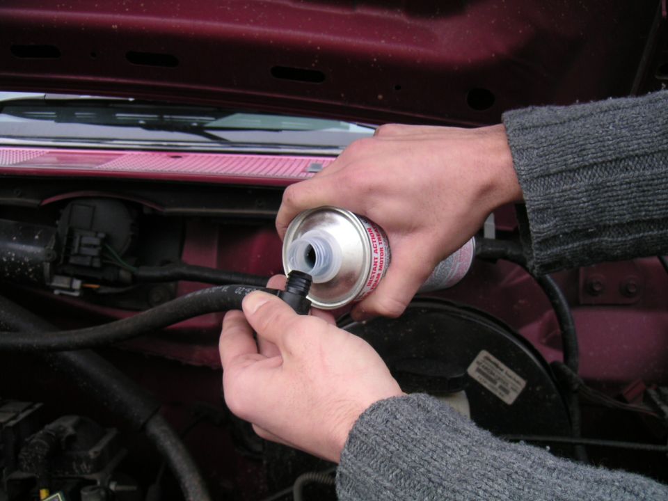1994 Ford Bronco engine bay, pouring fluid into hose