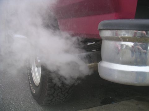 1994 Ford Bronco - Thick exhaust smoke is exiting the tailpipe of a vehicle.