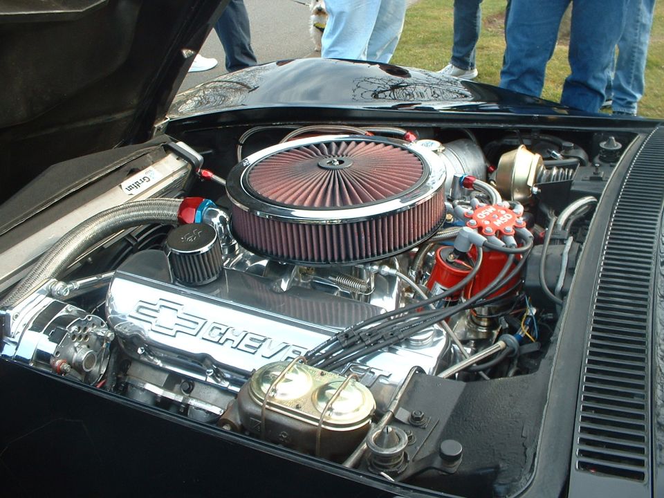 Engine bay with chrome Chevrolet valve covers, red air filter, and brake fluid reservoir