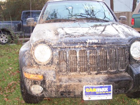 1989 Ford Bronco - This Jeep Liberty is covered in mud, with a CarMax license plate frame visible on the front bumper.