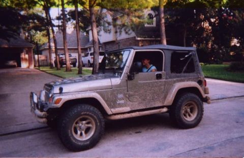 1989 Ford Bronco - This Jeep Wrangler is parked in a residential driveway, showing its side and front quarter view.