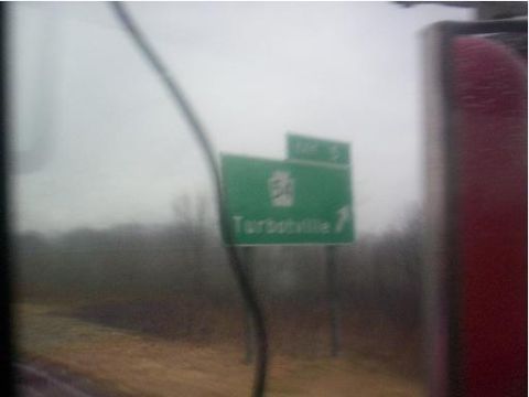 1971 Ford Mustang - A green highway sign indicates the exit for Turbotville, viewed from inside a moving vehicle.