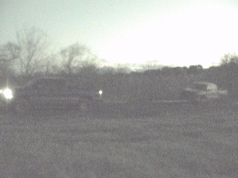 1989 Ford Bronco - Two vehicles are visible on a road during twilight hours.
