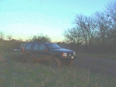 1989 Ford Bronco - Jeep Grand Cherokee is stuck in the mud off-road.