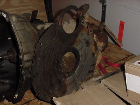 1995 Ford Bronco - Close-up of a transmission bell housing and a rusty adapter plate, likely for an older vehicle.